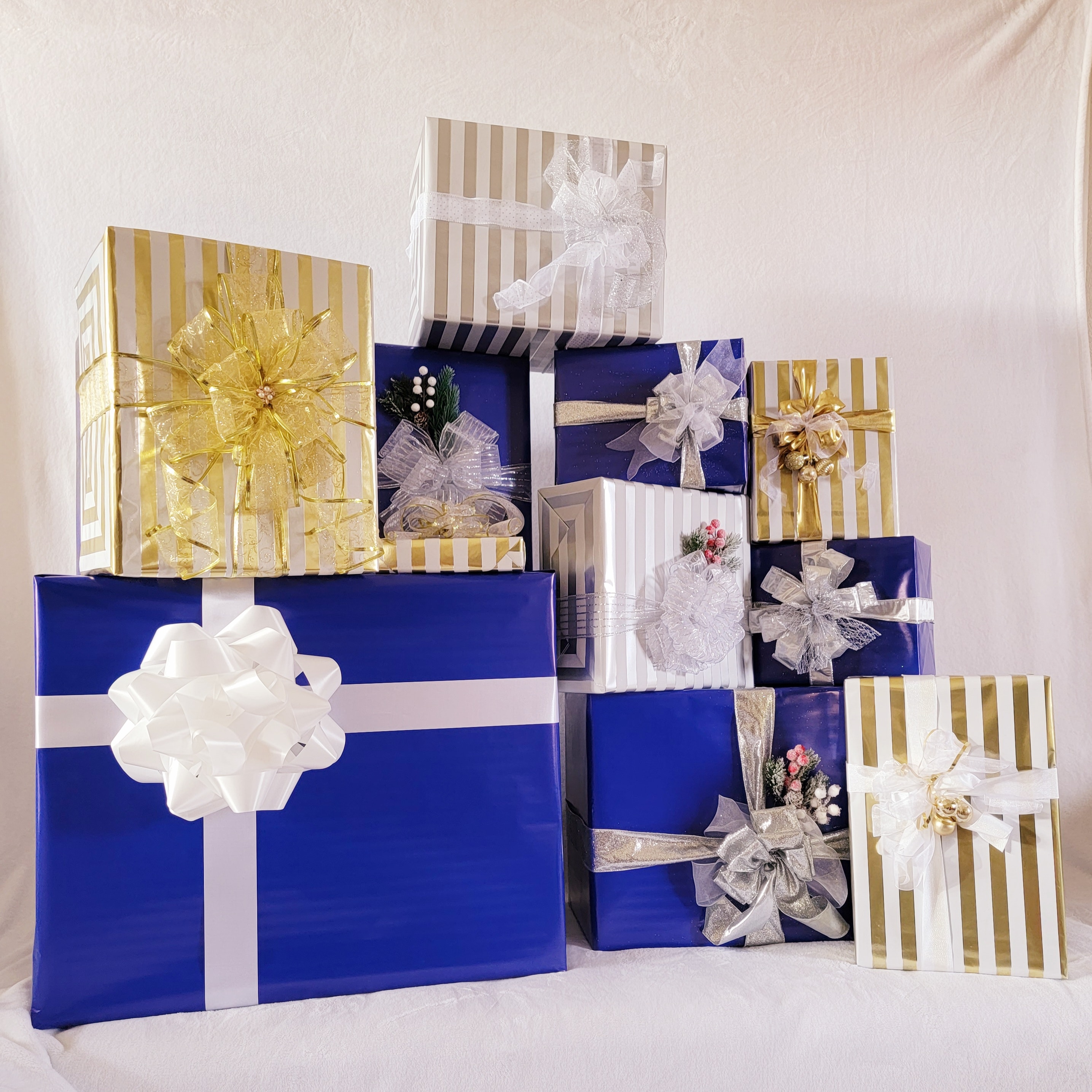 Collection of beautifully wrapped corporate gift boxes in navy blue, gold, and silver